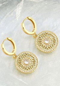 Guldörhängen med cirkulär filigran-design, med en central klar sten omgiven av små klara kristaller.