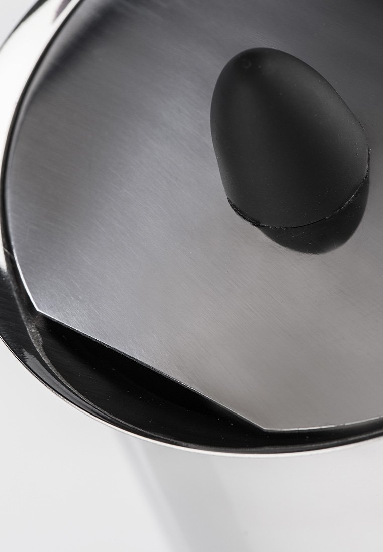 Gros plan sur le couvercle d'un conteneur en acier inoxydable avec une poignée en plastique noire et arrondie sur le dessus.