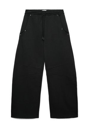 Pantaloni di tuta neri con vita elasticizzata, coulisse e quattro tasche. Presentano un tessuto testurizzato e dettagli di cucitura unici sulle gambe.