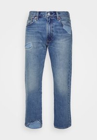 Blå denimjeans med rak passform, som har synlig slitage och lappar på fickorna, subtil blekning och koppardetaljer.