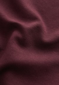 Burgundy cotton fabric with a smooth texture, displaying soft drapery and subtle sheen, featuring an even and consistent weave pattern.