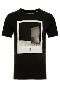 Černé tričko s logem PlayStation a grafikou konzole PlayStation 2 stojící vzpřímeně na povrchu podobném měsíci.