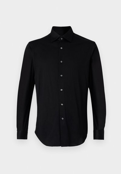 Svart langermet skjorte laget av glatt stoff, med spiss krage, full frontplacket med knapper, og med mansjetter som lukkes med knapper.