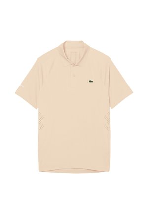 Polo beige à manches courtes avec col, patte à deux boutons, logo crocodile Lacoste sur le côté gauche de la poitrine et petits détails perforés sur les côtés.