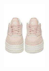 Rózsaszín velúr és bőr sportcipők, vastag fehér platform talppal, kerek orral és fűzővel; a Reebok logóval a nyelvén.