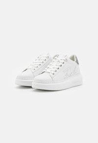 Hvite lær sneakers med avrundede tær, snørelukking og preget logo på siden. Har en teksturert hælakkent og plattformsåle.