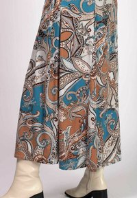 Flerfärgad kjol med paisleymönster som har blå, bruna och vita toner. Flödande tyg med en medellång design och dekorativa detaljer.