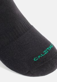 Calcetín negro hecho de un material suave, con una parte superior acanalada y un cuerpo liso. Incluye texto verde que dice "CALITAIL" cerca del dedo del pie.
