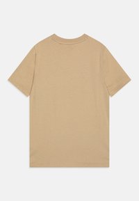 T-shirt en coton beige à manches courtes, design minimaliste et col rond. Texture lisse, couleur uniforme, sans motifs ni graphismes visibles.