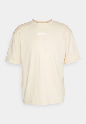 T-shirt en coton beige à manches courtes, col rond, avec un logo blanc imprimé sur le devant. Design simple, couleur unie sans motifs.