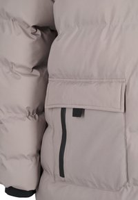 Ljusgrå puffjacka med en texturerad, quiltad design, en horisontell ficka med lock och en kontrasterande svart dragkedjedetalj.