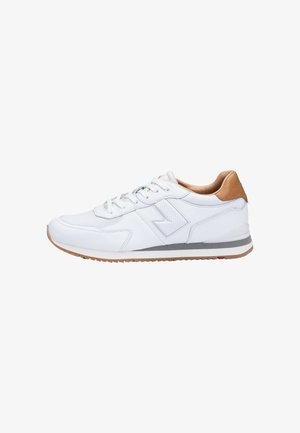 Sneaker bianco con lacci, linguetta del tallone marrone chiaro, suola grigia e bianca e dettaglio a zigzag cucito sul lato.