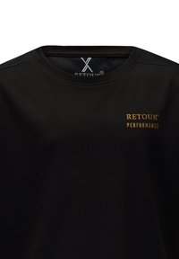 Maglietta sportiva nera con un motivo testurizzato, scollatura a coste e pannelli sulle spalle accentuati. Presenta il logo dorato "RETOUR PERFORMANCE".