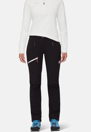 Black outdoor pants with a slim fit, featuring two front pockets and a diagonal zip pocket. Includes a white logo and orange zipper accents.