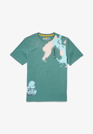 Maglietta Timberland verde a maniche corte con design astratto di schizzi di vernice beige e azzurro chiaro e testo del logo nero sul petto e sull'orlo.