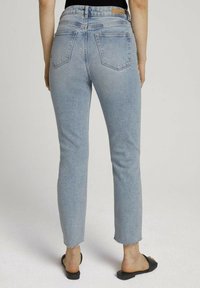 Ljust blå denimjeans med slim fit, fransad fåll och två bakfickor. Tillverkade i ett mjukt tyg, har en medelhög midja och bälteshällor.