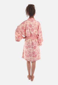 Perzische kimono-stijl robe met bloemmotieven in het rood. Het heeft brede mouwen, een elastische taille en valt boven de knieën. Soepele textuur.