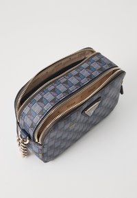 Beauty case con stampa blu e nera, dotata di zip dorate, dettagli in pelle e etichetta del marchio. Progettata con due compartimenti principali.