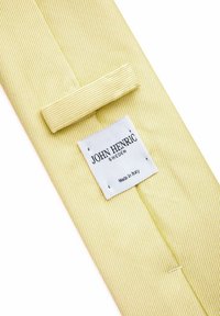 Gul slips med ett strukturerat randmönster; har en sydd ögla och en etikett som säger "JOHN HENRIC," vilket indikerar produktion i Italien.