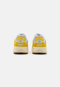 Saucony GRID Sneaker aus weißem Mesh mit gelben Wildlederakzenten, ausgestattet mit gepolsterten Sohlen und Logodetails an der Ferse und Seite.