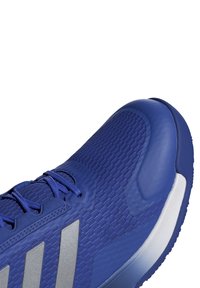 Blauwe sport sneaker met een gestructureerde bovenkant, verstevigde neus en zilveren strepen. Heeft een gevoerde tong en veters voor een veilige pasvorm.
