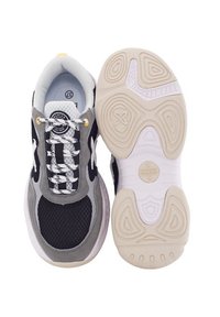 Zapatillas negras y grises con parte superior de malla, cordones blancos y un patrón de suela único. Presenta una puntera redondeada y un sutil detalle del logo en la lengüeta.