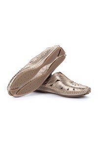 Chaussures en cuir doré avec des motifs découpés, texture douce et semelle flexible. Comprend des semelles légèrement rembourrées et un bord cousu.