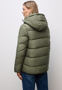 Khaki-färgad puffjacka med huva, utrustad med quiltade sektioner, slät yta och en liten logopatch på axeln. Standard passform, mittlång.