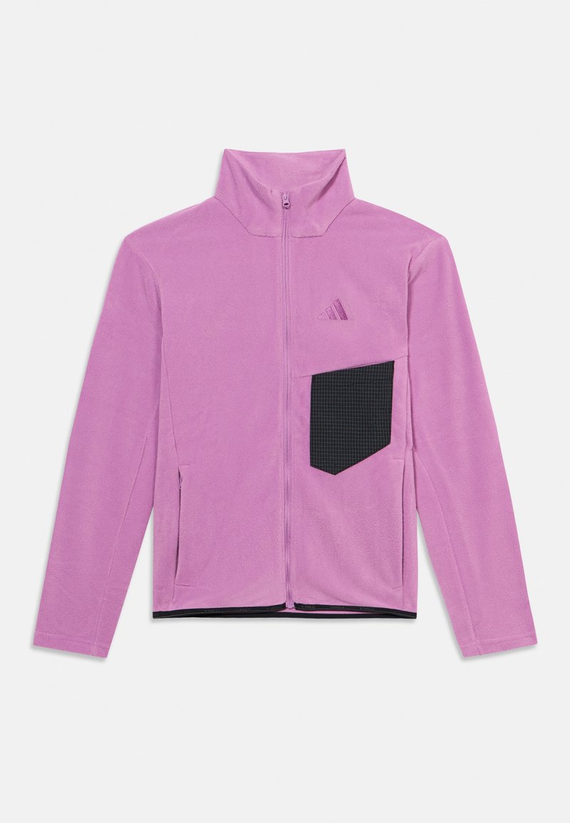 Veste rose à fermeture éclair avec un col montant, fabriquée en tissu doux. Elle comporte une poche noire à carreaux sur la gauche ainsi que deux poches latérales.