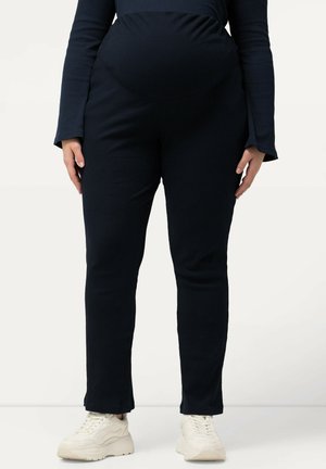 Námořnické pruhované těhotenské kalhoty s elastickým páskem, slim fit a mírně rozšířeným spodním lemem. Nosené s světlými teniskami.