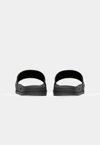 Sorte slidesandaler med en glat gummi øverdel, minimalistisk design, åben hæl og tekstureret sål for greb og komfort.