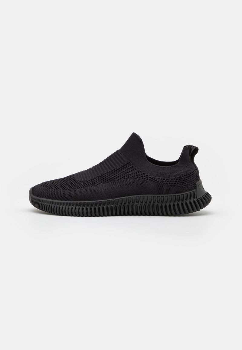 Black slip-on sneaker with a breathable mesh upper, textured design, and a ribbed rubber sole for enhanced grip and flexibility.