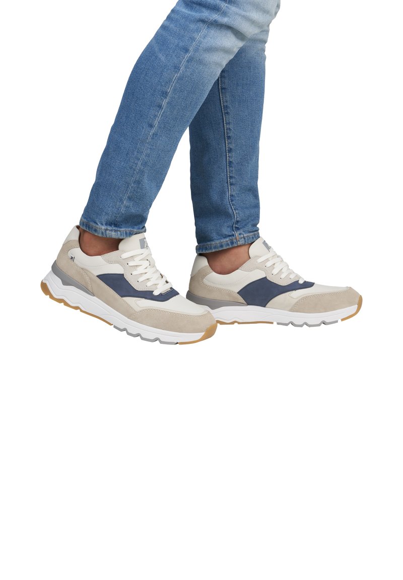 Baskets présentant un mélange de daim gris clair et de matériaux synthétiques blancs, avec des accents bleu marine, une épaisse semelle blanche et un design à lacets.