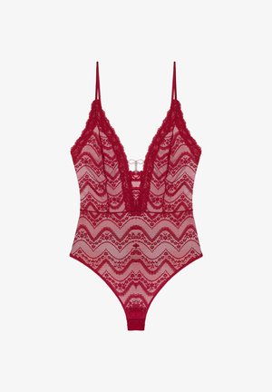 Body en dentelle rouge présentant un motif en zigzag, un décolleté en V profond, des bretelles fines et une quincaillerie décorative à l'avant. Texture semi-transparente sur l'ensemble.