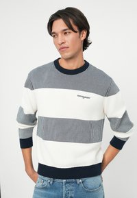 Pulover bărbați cu dungi, având benzi alternante de navy, alb și gri. Textură cu nervuri, gât rotund și broderie de marcă pe piept.