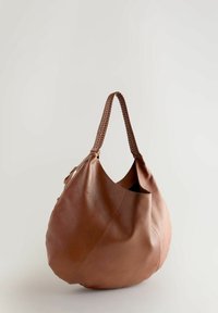 Ruskea nahkainen hobo-laukku, jolla on löysä muoto, letitetty kahva, sileä pinta ja minimalistinen muotoilu. Sisältää yhden suuren osaston.