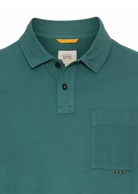 Teal bomulds polo shirt med krave, to sorte knapper og en brystlomme med en kontrasterende stofdetalje.