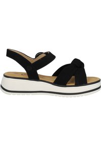 Sandalias negras con un diseño de tiras anudadas, material de ante suave, plantilla acolchada y una suela de plataforma blanca con líneas de acento negras.