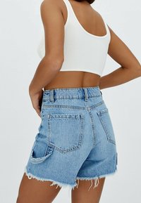 Jeansshorts i ljusblått, med en fransad fåll, fem fickor och hög midja med en subtil vintage-vask.