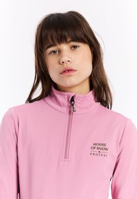 Roze fleece jack met rits en hoge kraag, voorzien van een logo op de borst. Glad textuur en sportief ontwerp geschikt voor buitenactiviteiten.