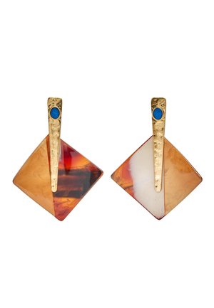 Kwadratowe kolczyki z marmurkową żywicą w kolorze bursztynu i kremu, złoconymi teksturowanymi prętami, każdy zakończony małym, okrągłym, niebieskim kamieniem.