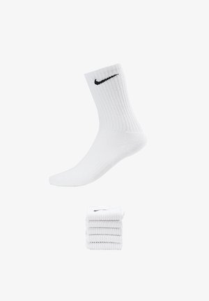 White cotton crew socks with ribbed texture featuring a black Nike swoosh logo. Presented with a folded stack of multiple pairs.