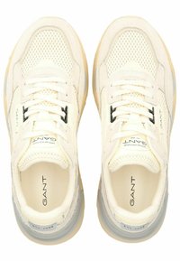 Weiße Sneaker mit Mesh- und Wildlederpaneelen, strukturiertem Laufsohle, flachen Schnürsenkeln und schwarzen Logoakzenten. Gepolsterter Schaft und gepolsterte Innensohle.