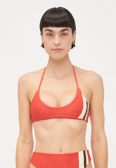 Haut de bikini rouge avec des bonnets triangulaires et des fines bretelles, présentant un accent rayé crème et marron d'un côté. Tissu lisse et élastique.