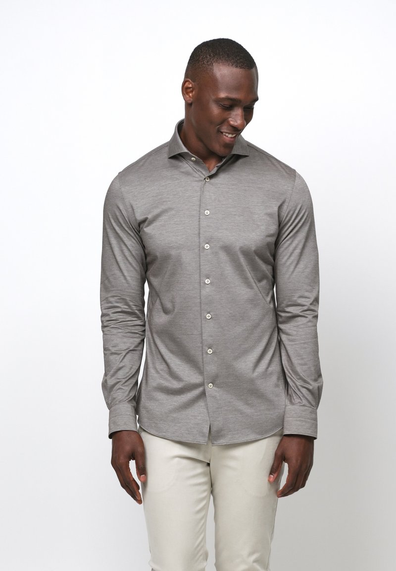 Lichtgrijs overhemd met lange mouwen in een slim fit, met een knoopsluiting aan de voorkant en een soepele, gestructureerde stof. Gecombineerd met lichtgekleurde broeken.