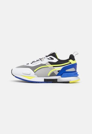 Low-top atletisk sneaker med grå, hvid, sort, blå og neon gul accenter, med snørebånd og en polstret sål.