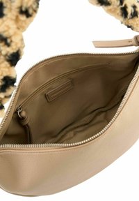 Sac en cuir beige avec une surface texturée, dotée d'une fermeture à glissière et d'une poche intérieure. Intérieur doublé d'une finition lisse.