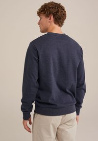 Marinblå sweatshirt i texturerad, stickad tyg, rund halsringning och ribbade ärmslut och nederkant. Ren design, inga synliga logotyper eller dekorationer.