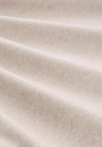 Lichtbeige stof met een fijne ribbelstructuur, die subtiele, golvende patronen en een gladde, zachte oppervlakte toont.