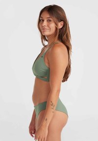 Grünes Bikini-Set mit einem Dreiecks-BH und seitlichen Cut-outs sowie einer glatten Oberfläche, kombiniert mit passenden niedrig geschnittenen Slips.